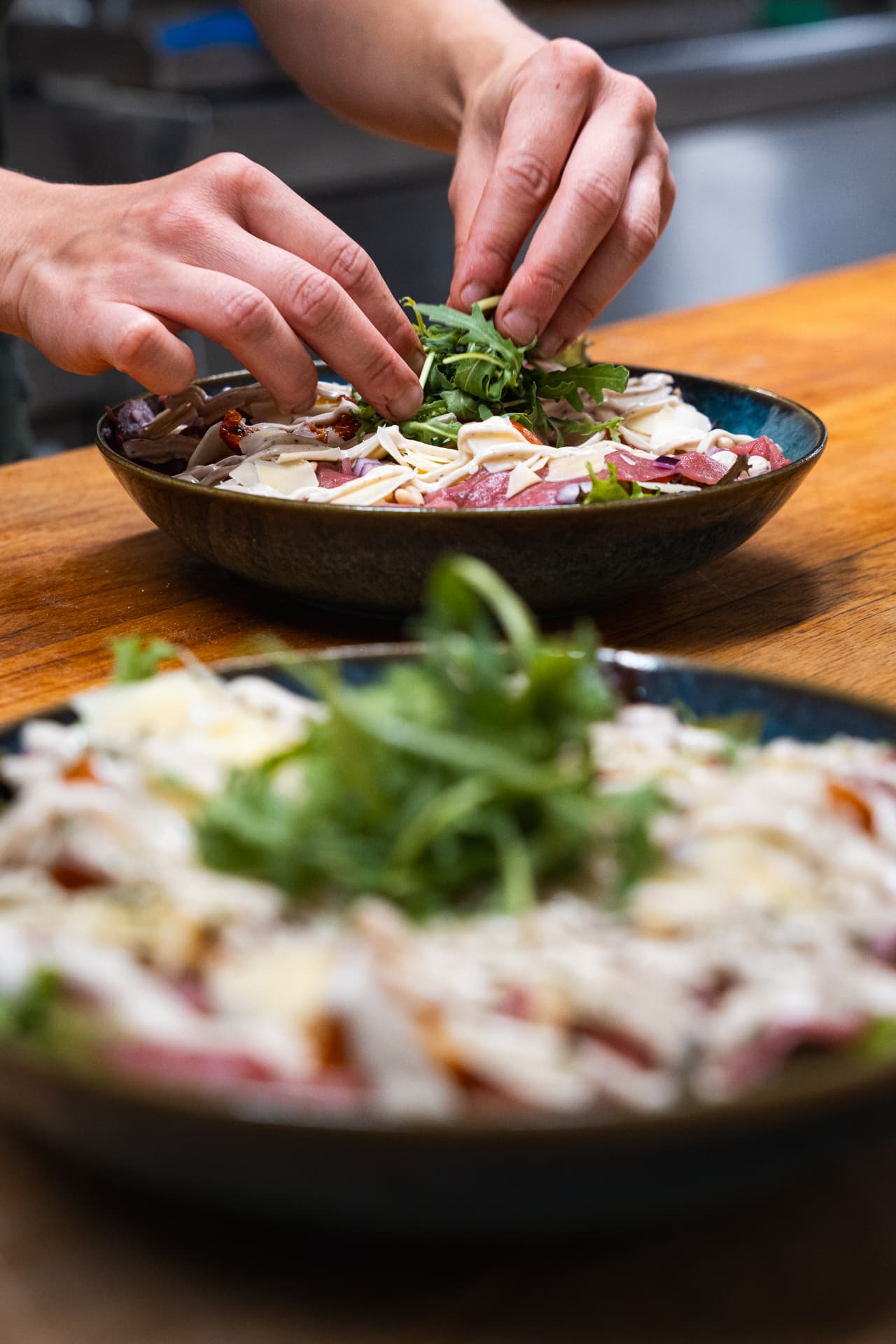 Een gerecht wordt met de hand opgemaakt in de keuken