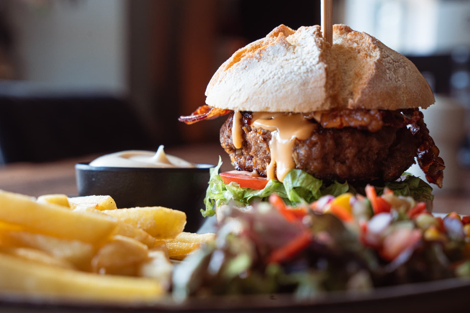 Een burger met friet op tafel in de bistro